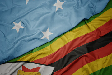 waving colorful flag of zimbabwe and national flag of Federated States of Micronesia .