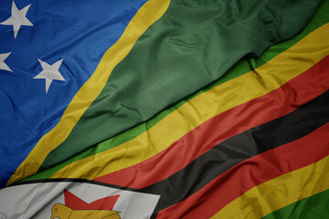 waving colorful flag of zimbabwe and national flag of Solomon Islands .