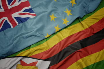 waving colorful flag of zimbabwe and national flag of Tuvalu .