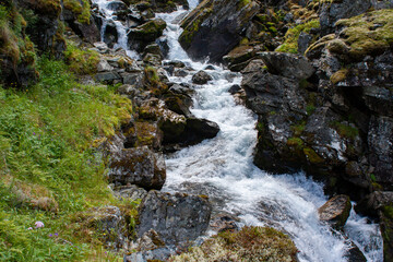 A stream flows down the mountains through the rapids