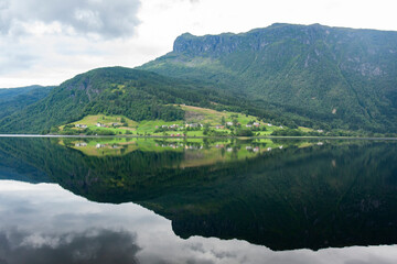 Fototapeta premium Beautiful reflection of the hillside on fjord water surface in Norwegian countryside