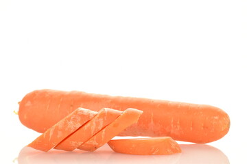 Several slices of fresh organic, unpeeled carrots in the foreground, in focus. In the background is one carrot. The background is white.