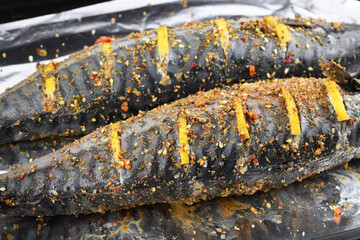 Raw sea fish with lemon and spices on foil, top view. Healthy food or diet food concept. Cooking fish dishes from various ingredients