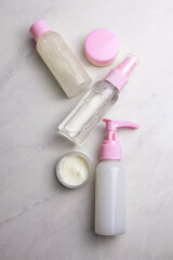 Bottles with cosmetic for facial and body care on light background