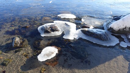 Ice-filled rocks by the sea on a sunny winter day