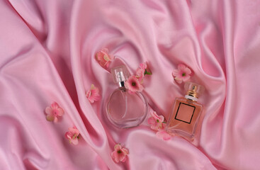 perfume bottles on silk pink fabric with flowers