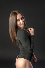 fitness woman gym black. In a black bathing suit. hip, human leg healthy lifestyle. Athlete figure, slimming silhouette. Half-side turn portrait