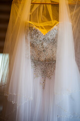 The bride's dress hangs on a hanger