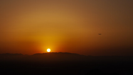 Sunset of the mountain whit a airplane in the air