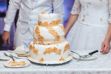 Three-tiered wedding cake decorated with gold filigree and fireworks