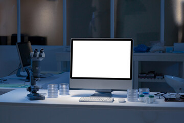 Desktop computer with illuminated screen at workstation in medical laboratory