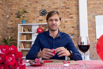 Caucasian man making video call opening a small gift box and smiling