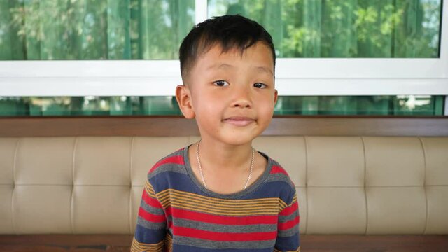 A cute Asian boy smiling.