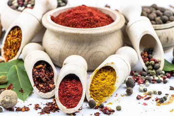 Spices in wooden tableware by close up on a white background.
