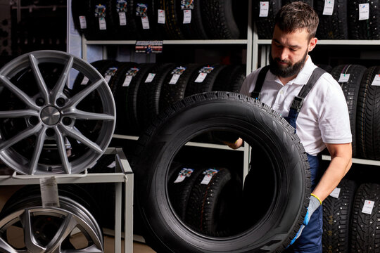 owner garage shop holding best tire in a supermarket mall, measuring rubber car wheel. at work place