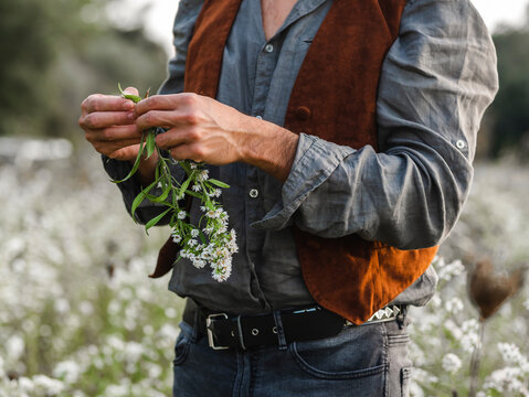 Crop unrecognizable gay while standing in blooming meadow in sunny day