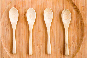 Empty wooden spoon on the wooden plate, wooden dishware