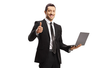 Smiling businessman with a laptop showing thumbs up