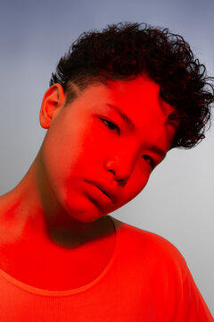 Magnificent portrait of a beautiful young Latina woman with a color red filter. Tinted photo, blue gradient background
