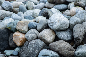 Rounded ocean rocks sitting piled on a Washington beach.