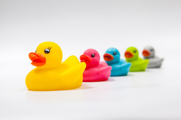 Bigger yellow rubber duck leading row of multicolored rubber ducks