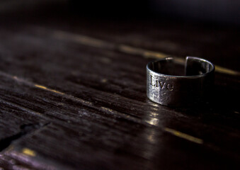 A silver ring with an inscription on a dark background. Life. High quality photo