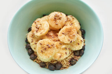 Healthy breakfast. Top view. Oatmeal with banana and flax seeds at bowl. Berry in plate. Organic meal recipe. Vegan cook. Minimalism granola. Hot porrigde with fruit