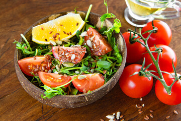  Healthy microgreen salad with tomatoes, lemon and seeds close-up