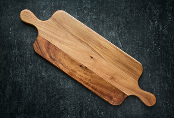 Long cutting wooden board on a gray background. Top View