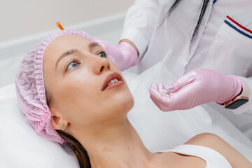 Cosmetology procedure for lip augmentation and wrinkle removal for a young beautiful girl....