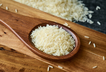 Grains of Basmatti rice on a wooden spoon close up, macro