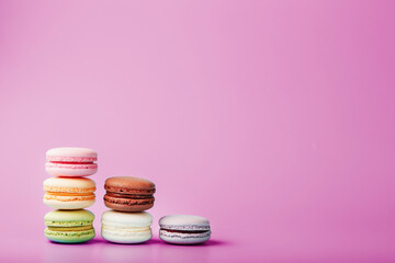 Colorful French macaroni cookies are arranged in a pyramid on the background.