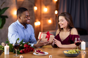 Caring Black Guy Surprising Girlfriend With Present On Romantic Date In Restaurant