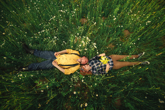 couple lying in a field of flowers. Happy couple lie in a flower. Romance, emotional and love scene.