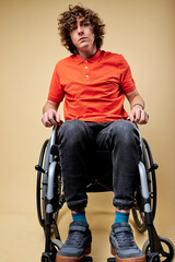 serious sick invalid man can't walk, sits alone on wheelchair, feeling himself lonely and unhappy,...