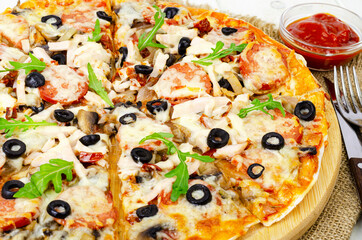 pizza with salami, ham and mozzarella on wooden table