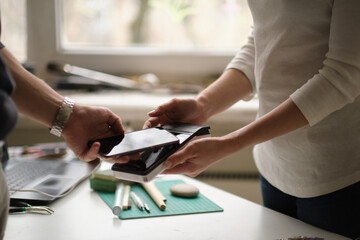 NFC technology. Customer is paying. Close up of guest using smart phone while making contactless...