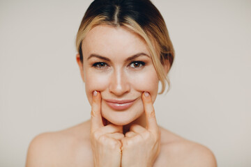 Young adult doing facial gymnastics self massage and rejuvenating exercises face building for skin...