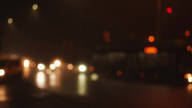 Blurry 4k stock video footage of night traffic lights glowing in darkness