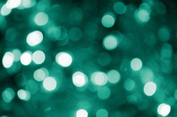 Fototapeta na wymiar Bokeh magical blur background. Festive green luminous background.