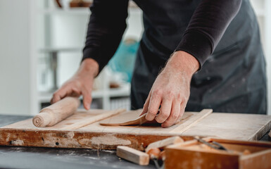 Man using rolling pin on clay