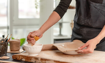 Woman using wet sponge for plate forming