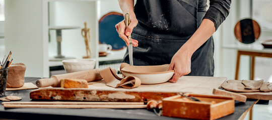 Woman using knife for plate forming