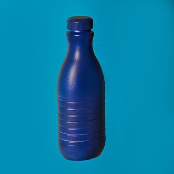 Blue plastic container from liquid detergent placed on vivid blue background in studio