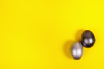 Multi-colored eggs on a uniform yellow background with place for text.