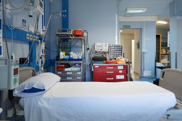 Interior of contemporary hospital room with empty bed and modern electronic medical equipment