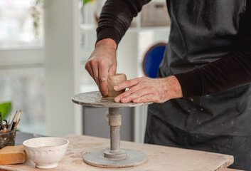 Fototapeta na wymiar Man using pottery wheel for molding