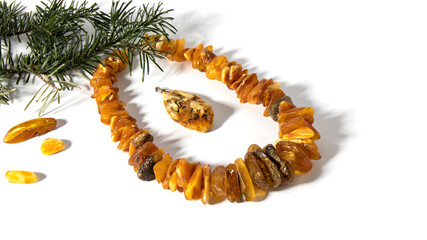 Amazing Baltic necklace made of different colors and types of  raw and polished ancient  amber stone.  Isolated amber jewelry on a white background.  Transparent and with plant and flowers inclusion