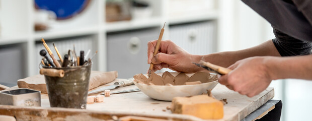 Woman using carving tool on plate