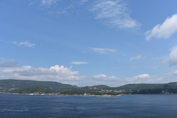 land and mounatins across the blue ocean on a summer day